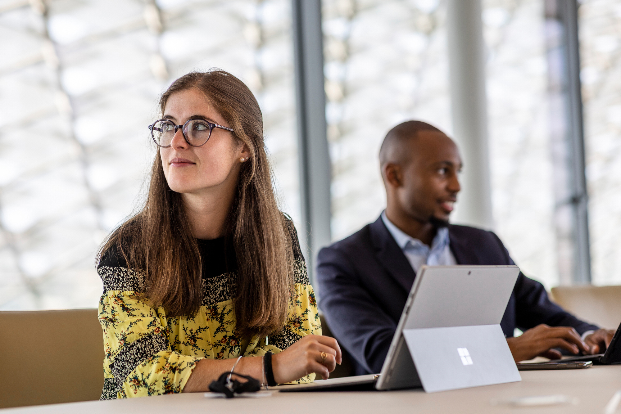 A woman thinking with a man in the background